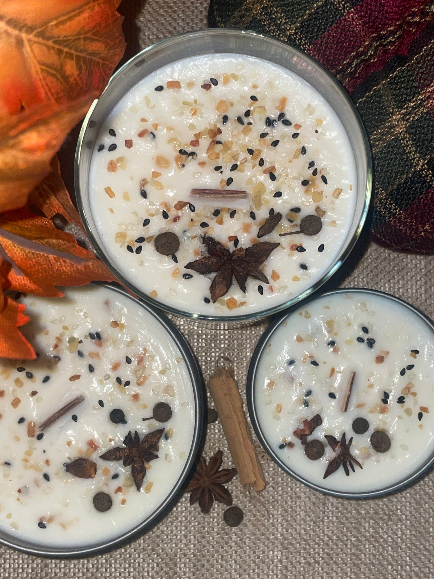 Three candles with spices on a soft soy wax surface.